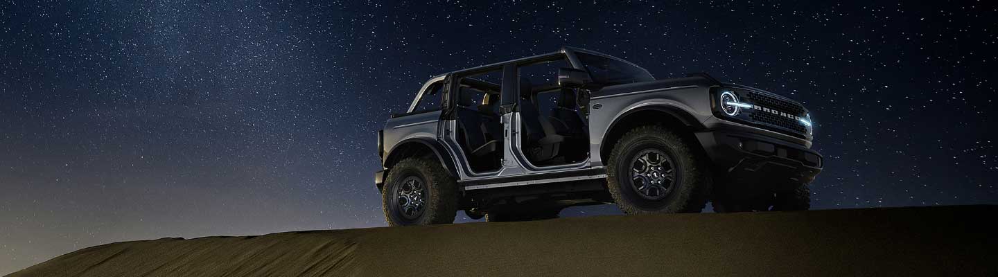 Bronco en la noche con techo y puertas desmontadas