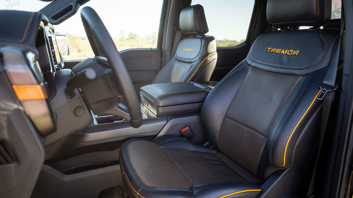 Asientos tapizados en cuero de alta calidad con costura de color naranja cobre