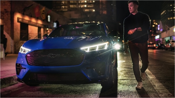 Hombre al lado de un Mustang Mach-E azul