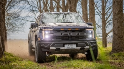 Perfil izquierdo de la camioneta F-150 Raptor blanca en la arena