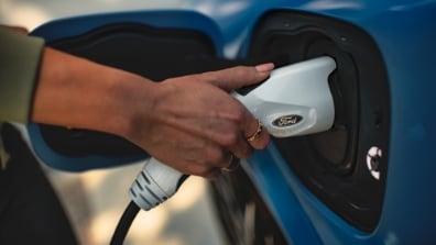 Una persona cargando su auto en su casa